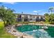 Inviting townhouse featuring a tranquil pond view with a fountain, lush landscaping, and screened patios at 1998 Blue Hawk Ct # 1613, Clearwater, FL 33762