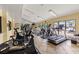 Well-lit gym with modern cardio equipment and large windows overlooking the pool and outdoor area at 1998 Blue Hawk Ct # 1613, Clearwater, FL 33762