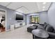Relaxing living room includes mounted TV, comfortable sofa and views of the pool through screened windows at 1998 Blue Hawk Ct # 1613, Clearwater, FL 33762