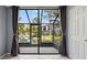 Enclosed screened patio with curtains that offer a serene view of the pond at 1998 Blue Hawk Ct # 1613, Clearwater, FL 33762