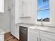 Modern kitchen features white cabinets, stone counters and stainless steel dishwasher at 2050 Hawaii Ne Ave, St Petersburg, FL 33703