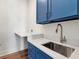 Laundry room features blue cabinets, stainless sink and stone countertop at 2050 Hawaii Ne Ave, St Petersburg, FL 33703