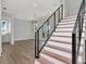 Modern staircase with wood treads and black metal railings leads to the upper level of the home at 2050 Hawaii Ne Ave, St Petersburg, FL 33703
