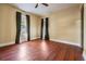 Spacious bedroom featuring sleek hardwood floors, a ceiling fan, and sunlit windows at 2414 W State St, Tampa, FL 33609