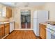 Kitchen featuring standard appliances, wooden cabinets and a view into the living room at 2414 W State St, Tampa, FL 33609