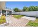 Landscaped backyard featuring a paved pathway and screened-in porch at 2755 Merlin Way, Clearwater, FL 33761