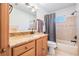 Bathroom features a granite countertop, wooden cabinets, and shower with tub and gray shower curtain at 2755 Merlin Way, Clearwater, FL 33761