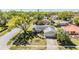 Aerial view of a cozy, single-story home with a well-kept lawn and mature shade trees at 2755 Merlin Way, Clearwater, FL 33761
