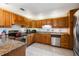 Eat in kitchen featuring updated appliances, stone countertops, and wooden cabinetry at 2755 Merlin Way, Clearwater, FL 33761