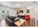 Comfortable living room with a black leather couch, stone wall, and lots of natural light at 2755 Merlin Way, Clearwater, FL 33761