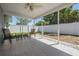 Covered patio with tile flooring and outdoor furniture, overlooking a fenced backyard at 2755 Merlin Way, Clearwater, FL 33761