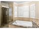 Elegant bathroom featuring a soaking tub, walk-in shower with glass door and natural stone accents at 2920 W El Prado Blvd # 4, Tampa, FL 33629