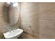 Small powder room features textured wallpaper, pedestal sink and oval mirror at 2920 W El Prado Blvd # 4, Tampa, FL 33629