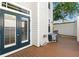 Back deck area with wood flooring, surrounded by an air conditioning unit and exterior door at 2920 W El Prado Blvd # 4, Tampa, FL 33629