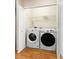 Convenient laundry closet with a washer, dryer, storage shelf, and hardwood floors at 2920 W El Prado Blvd # 4, Tampa, FL 33629