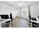 Bright bedroom with wood floors, a ceiling fan, and lots of natural light from the large window at 30132 Wellesley Way, Wesley Chapel, FL 33543