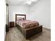 Bedroom features a bed, storage chest and wood-look floors at 30132 Wellesley Way, Wesley Chapel, FL 33543