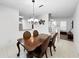 Traditional dining room features a wood table, decorative chandelier and tile flooring at 30132 Wellesley Way, Wesley Chapel, FL 33543
