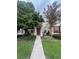 Charming home with a red front door, manicured lawn, complemented by mature trees and vibrant flowers at 30132 Wellesley Way, Wesley Chapel, FL 33543