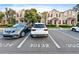 This exterior view shows the architecture of the townhome units with cars parked in front at 30132 Wellesley Way, Wesley Chapel, FL 33543