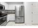 Bright kitchen with stainless steel refrigerator, sleek appliances, and white cabinetry at 30132 Wellesley Way, Wesley Chapel, FL 33543