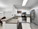 Well-lit kitchen featuring stainless steel appliances, white cabinets, and a stylish countertop bar at 30132 Wellesley Way, Wesley Chapel, FL 33543