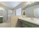 Bright bathroom featuring an enclosed shower, window, and vanity with a white countertop and green cabinets at 3138 Clover Blossom Cir, Land O Lakes, FL 34638