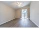 Spacious bedroom with hardwood floors, ceiling fan, and a sliding glass door to the screened porch at 3138 Clover Blossom Cir, Land O Lakes, FL 34638