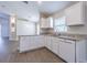 A well-designed kitchen offers granite countertops, white cabinets, and a view into the adjacent living area at 3138 Clover Blossom Cir, Land O Lakes, FL 34638