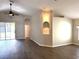 Open-concept living room with wood floors, ceiling fan, and sliding glass doors at 3138 Clover Blossom Cir, Land O Lakes, FL 34638