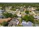 An aerial view captures a neighborhood's layout with homes, swimming pools, and well-maintained streets and greenery at 3388 Tarpon Woods Blvd, Palm Harbor, FL 34685