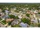 An aerial shot displays a residential area with diverse homes, tree-lined streets, and glimpses of backyard swimming pools at 3388 Tarpon Woods Blvd, Palm Harbor, FL 34685