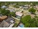 An aerial view showcases a home with a screened pool, surrounded by lush greenery in a suburban neighborhood at 3388 Tarpon Woods Blvd, Palm Harbor, FL 34685
