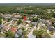 An aerial view shows a home within a neighborhood featuring lush landscaping and backyard swimming pools for outdoor enjoyment at 3388 Tarpon Woods Blvd, Palm Harbor, FL 34685
