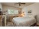 Cozy bedroom featuring a patterned bedspread, ceiling fan, and a window with white shutters at 3388 Tarpon Woods Blvd, Palm Harbor, FL 34685