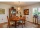 Traditional dining room with a wood table, chandelier, and a window with blinds at 3388 Tarpon Woods Blvd, Palm Harbor, FL 34685