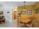 Sunny dining room boasts a round table, cushioned chairs, and warm golden-yellow walls at 3388 Tarpon Woods Blvd, Palm Harbor, FL 34685
