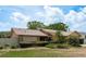 Charming single-story home featuring stone accents and a well-manicured lawn under a bright blue sky at 3388 Tarpon Woods Blvd, Palm Harbor, FL 34685