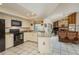 Bright, open kitchen, black appliances, and seamless flow into the living room with fireplace at 3388 Tarpon Woods Blvd, Palm Harbor, FL 34685