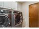 Laundry room featuring front loading washer and dryer appliances and a wood door at 3388 Tarpon Woods Blvd, Palm Harbor, FL 34685