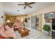 Living room featuring tan tile floors, ceiling fan, and access to the outside at 3388 Tarpon Woods Blvd, Palm Harbor, FL 34685