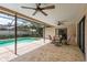 Covered patio area with ceiling fans, overlooking screened-in pool, with seating, and brick patio flooring at 3388 Tarpon Woods Blvd, Palm Harbor, FL 34685