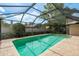 A screened-in pool with brick patio, offering a private and refreshing outdoor space at 3388 Tarpon Woods Blvd, Palm Harbor, FL 34685