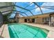 A screened-in pool with brick patio, outdoor seating, and privacy at 3388 Tarpon Woods Blvd, Palm Harbor, FL 34685