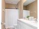 Bathroom with double sink vanity, shower, toilet, white fixtures and warm neutral paint at 34355 Sorrel Mint Dr, Wesley Chapel, FL 33543