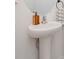 Pedestal sink with a round mirror and decorative hand towel at 34355 Sorrel Mint Dr, Wesley Chapel, FL 33543