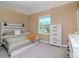 Bright bedroom features a serene palette, a large window, and a stylish whitewashed wooden headboard at 34355 Sorrel Mint Dr, Wesley Chapel, FL 33543