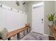Charming entryway with storage bench, coat hooks, decorative rug, and ample natural light at 34355 Sorrel Mint Dr, Wesley Chapel, FL 33543