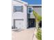 Close up of townhome featuring a pristine garage, dark front door and tropical landscaping at 34355 Sorrel Mint Dr, Wesley Chapel, FL 33543