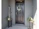 Inviting front door with a wreath, welcome sign, and stylish planters creating curb appeal at 34355 Sorrel Mint Dr, Wesley Chapel, FL 33543